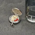 Un pastillero elegante con forma de reloj de bolsillo